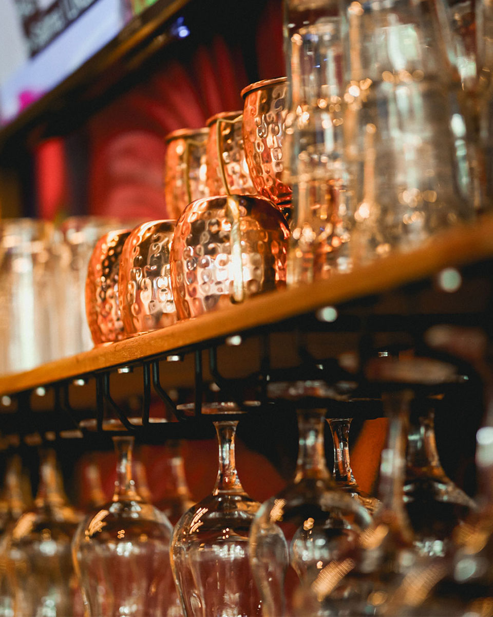 Empty glasses hanging over a bar rack in restaurant.