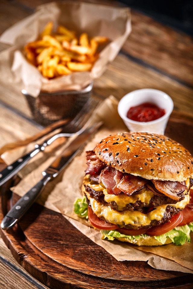A close-up shot of a burger and fries at a resturant table.